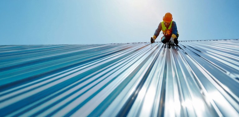 Roof worker attaching roof panels